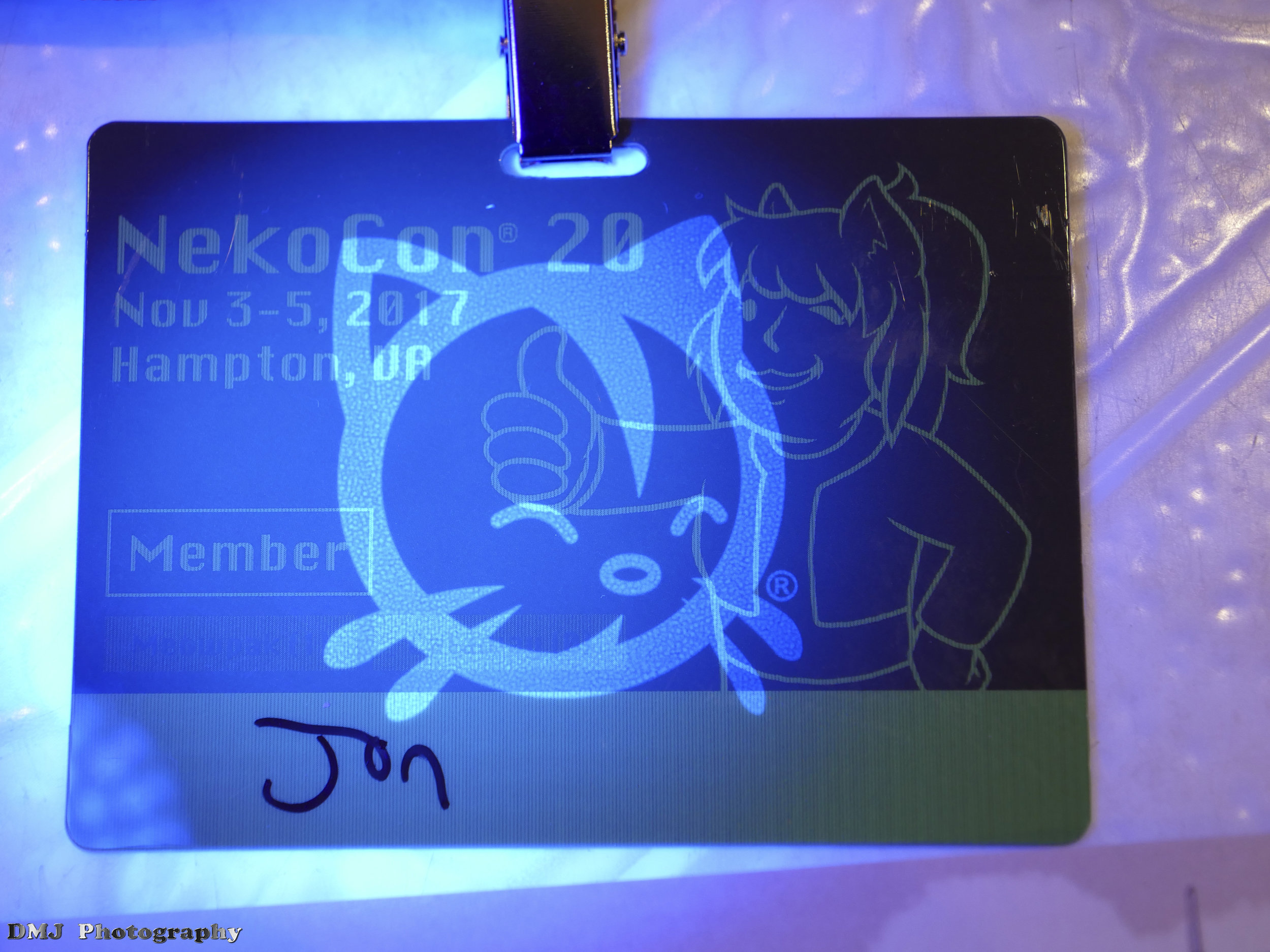 Shining a UV light on the badge reveals a neko hiding in plain sight